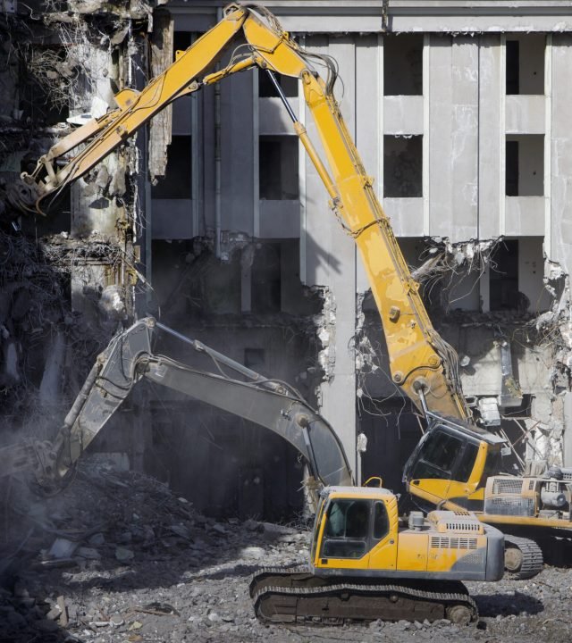 Building of the former hotel demolition for new construction, using a two special hydraulic excavator-destroyer. Complete highly mechanized demolition of building structures. Construction site